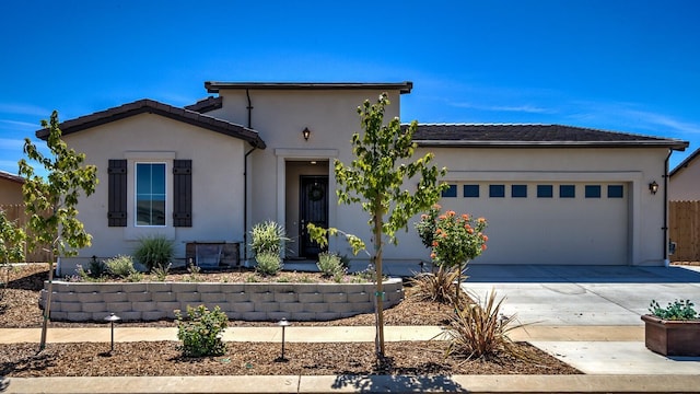 view of front of home with a garage, concrete driveway, a tile roof, and stucco siding