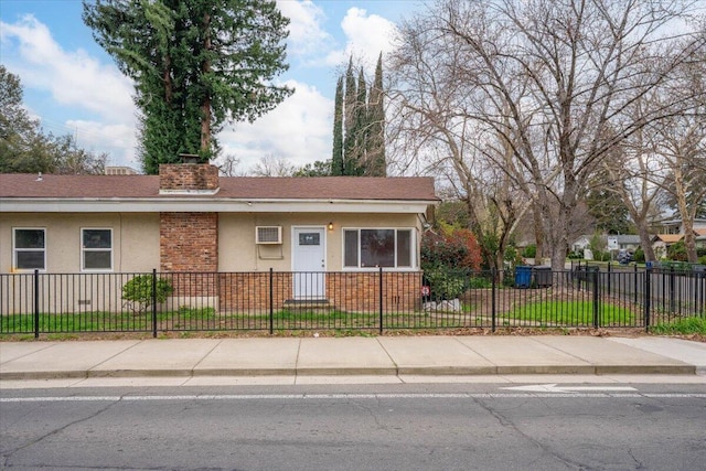 view of front of home with a fenced front yard, stucco siding, and a chimney