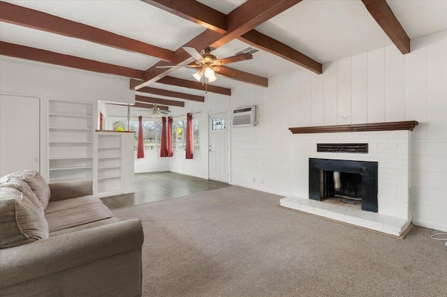 carpeted living area with a wall unit AC, a ceiling fan, visible vents, beam ceiling, and a fireplace