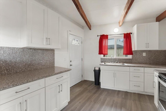 kitchen with white cabinetry, beam ceiling, wood finished floors, and a sink