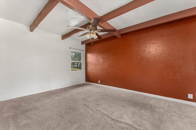 carpeted empty room with a ceiling fan, baseboards, beam ceiling, a textured ceiling, and a textured wall