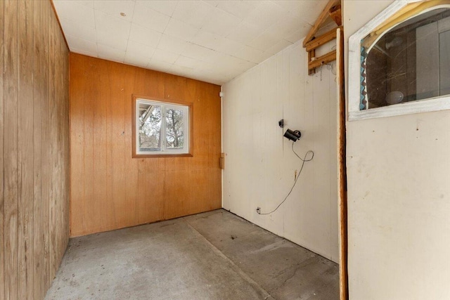 interior space featuring unfinished concrete floors and wood walls