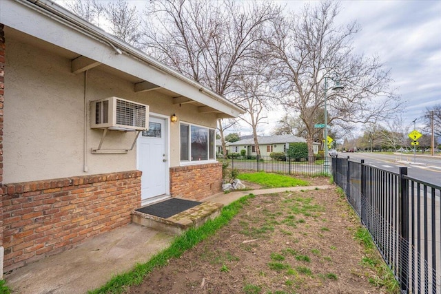 view of yard with fence and a wall mounted air conditioner