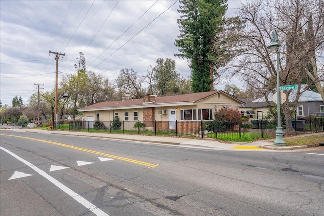 view of front of property featuring a fenced front yard and brick siding