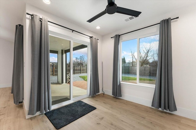 doorway to outside featuring light wood-style flooring, visible vents, and baseboards