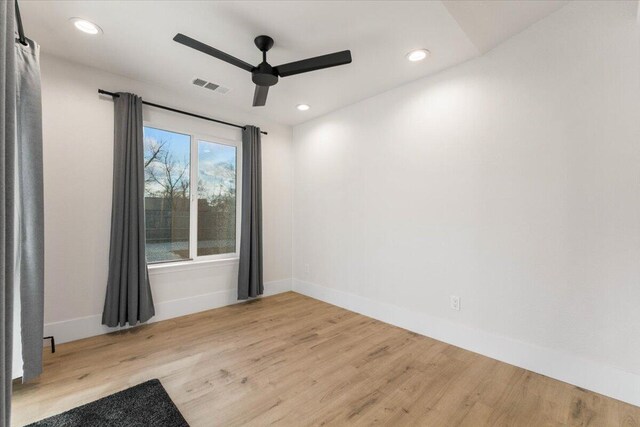 empty room with recessed lighting, visible vents, baseboards, and wood finished floors