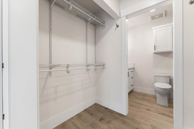 walk in closet featuring light wood-style flooring and visible vents