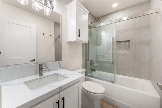 bathroom featuring vanity, toilet, and bath / shower combo with glass door