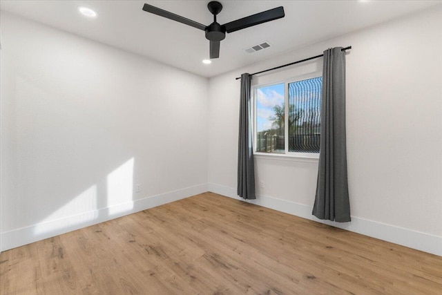 spare room with ceiling fan, wood finished floors, visible vents, and baseboards