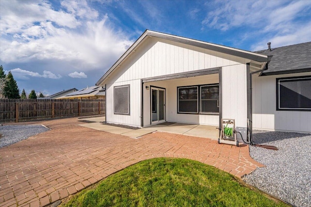 rear view of property featuring fence and a patio