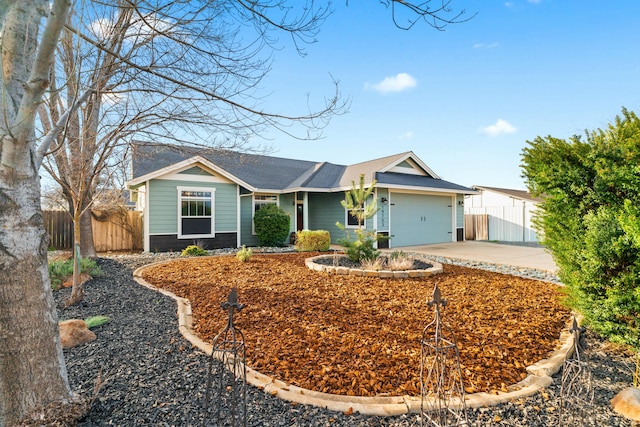 ranch-style house featuring an attached garage, a shingled roof, fence, and concrete driveway