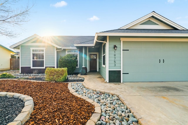 ranch-style home featuring roof with shingles, driveway, an attached garage, and fence