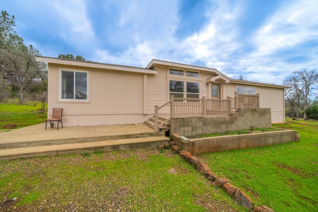 rear view of house with a lawn and a wooden deck