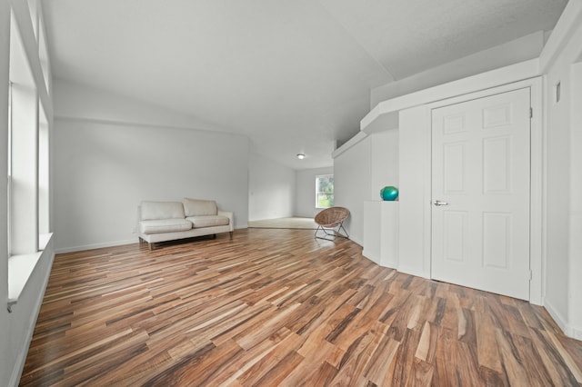 unfurnished room with lofted ceiling and wood finished floors