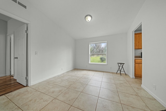 unfurnished room featuring light tile patterned floors, visible vents, and baseboards