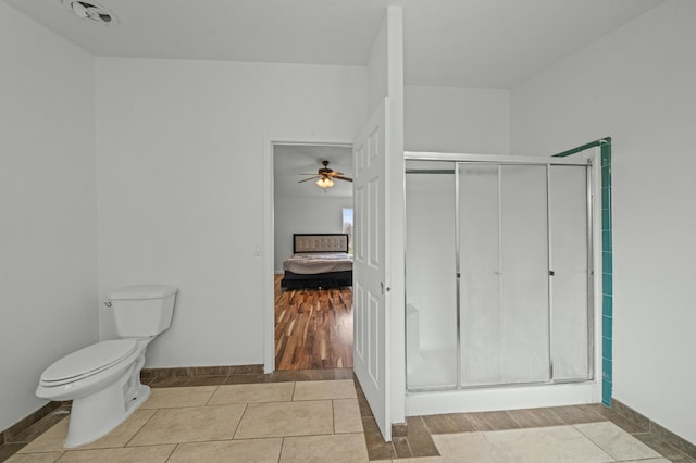 full bathroom featuring toilet, tile patterned floors, a shower stall, and ensuite bathroom