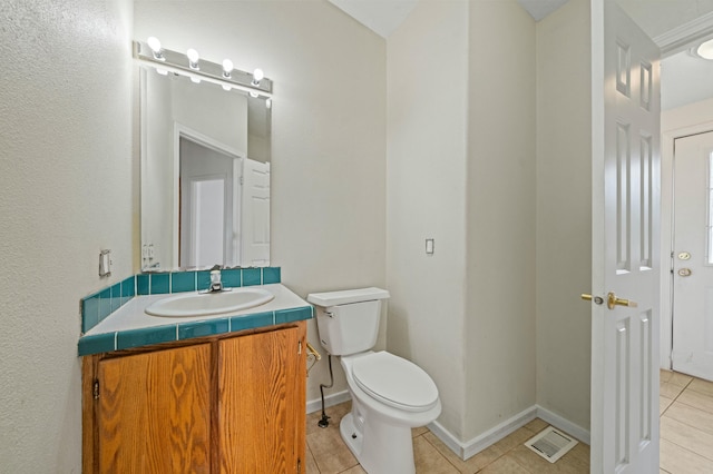 bathroom with toilet, vanity, visible vents, and tile patterned floors