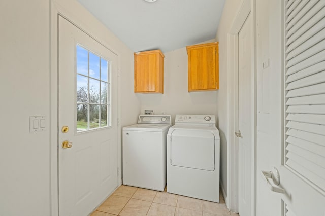 laundry area with washer and dryer, cabinet space, and light tile patterned floors