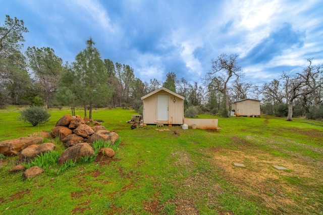 view of yard featuring a storage shed and an outbuilding