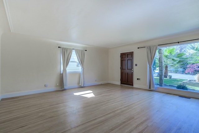 unfurnished room featuring baseboards, visible vents, and light wood-type flooring