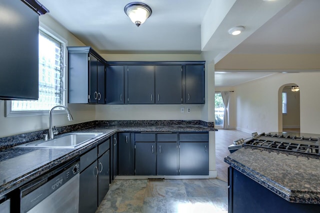 kitchen featuring stainless steel dishwasher, arched walkways, and a sink