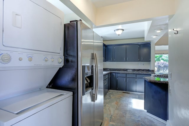 washroom featuring laundry area and stacked washer / dryer