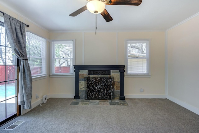 unfurnished living room featuring baseboards, visible vents, carpet floors, a tile fireplace, and crown molding