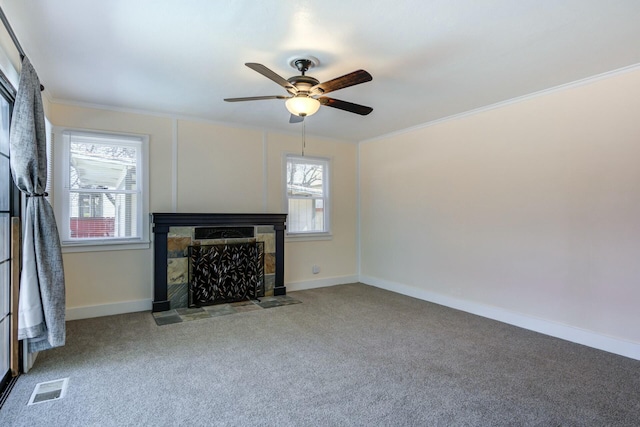 unfurnished living room featuring visible vents, a healthy amount of sunlight, a tile fireplace, and carpet