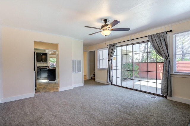 empty room featuring crown molding, baseboards, visible vents, and carpet floors