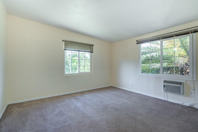 unfurnished room featuring baseboards, carpet floors, and an AC wall unit