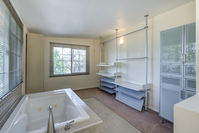 full bathroom featuring a tub with jets and baseboards