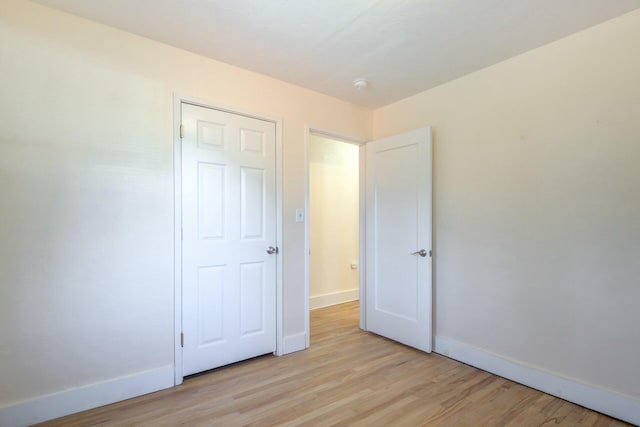 unfurnished bedroom featuring baseboards and light wood finished floors