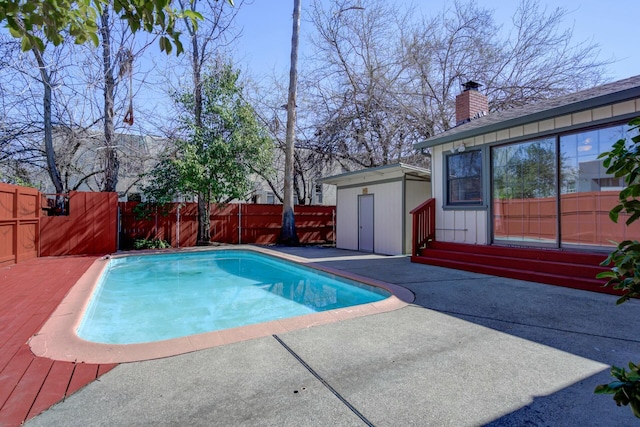 view of pool featuring an outbuilding, a fenced backyard, a fenced in pool, and a patio area