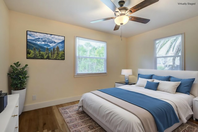 bedroom featuring baseboards, a ceiling fan, and dark wood-style flooring