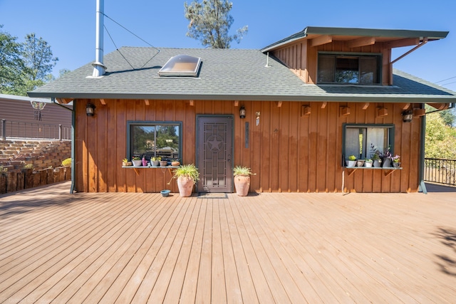 view of front of home with roof with shingles and a deck