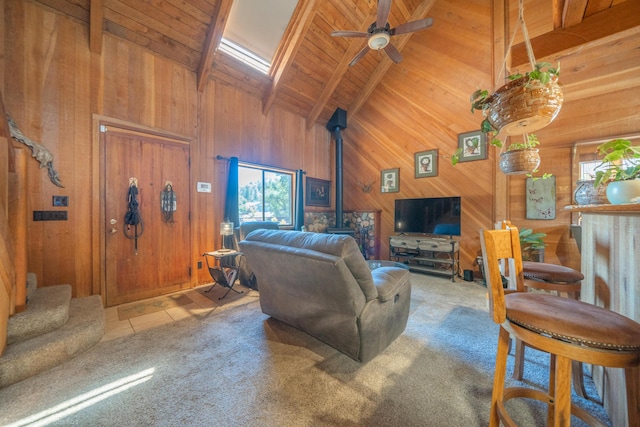 carpeted living area featuring wooden ceiling, wooden walls, stairs, beam ceiling, and a wood stove