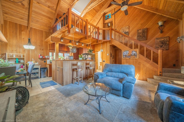 living area with light tile patterned floors, stairway, wood ceiling, and wooden walls