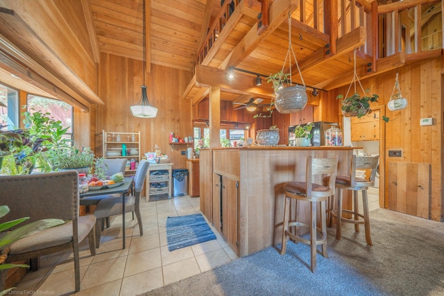 kitchen with light tile patterned floors, wood walls, wood ceiling, and track lighting