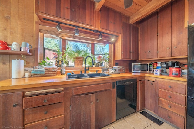 kitchen with light tile patterned floors, black dishwasher, butcher block counters, stainless steel microwave, and a sink