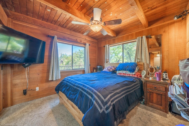 carpeted bedroom with wooden ceiling, multiple windows, and wooden walls