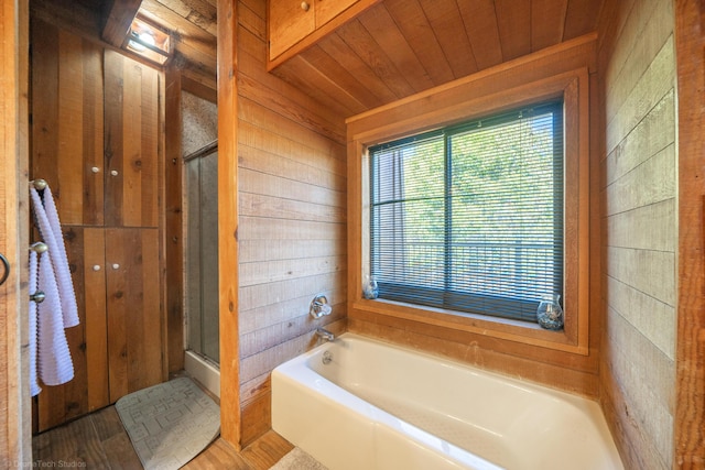 full bath featuring wood walls, wood ceiling, a garden tub, and a stall shower