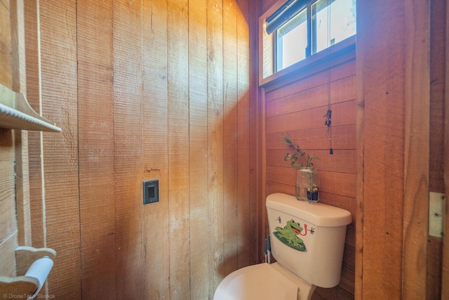 bathroom featuring toilet and wooden walls