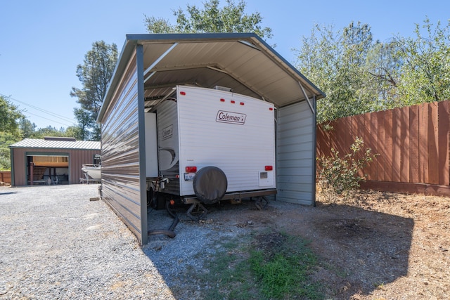 view of vehicle parking with fence and a carport