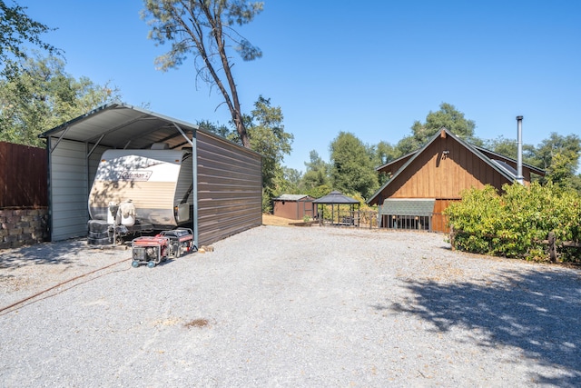 view of parking with a carport and gravel driveway