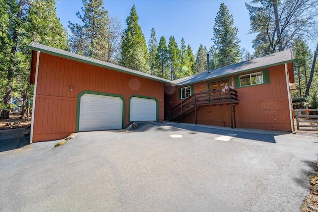 chalet / cabin with driveway and an attached garage