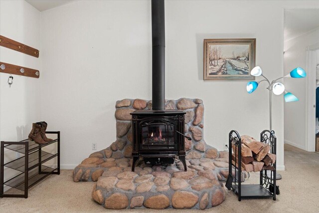 interior details featuring baseboards, a wood stove, and carpet