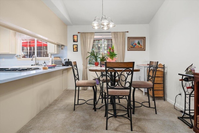 dining space featuring baseboards, an inviting chandelier, and light colored carpet
