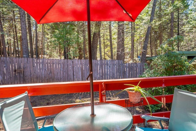 deck with a view of trees and fence