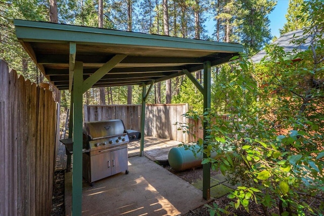 view of patio featuring a grill and fence