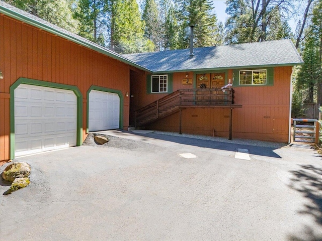 view of front facade featuring a garage and aphalt driveway